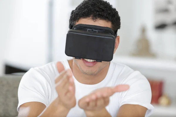 Joven feliz usando máscara de realidad virtual en casa —  Fotos de Stock