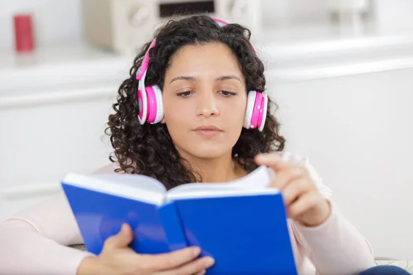 Жінка в навушниках слухає аудіокнигу — стокове фото
