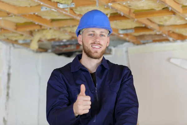 Constructor hombre posando mirando cámara y mostrar el pulgar hacia arriba signo —  Fotos de Stock