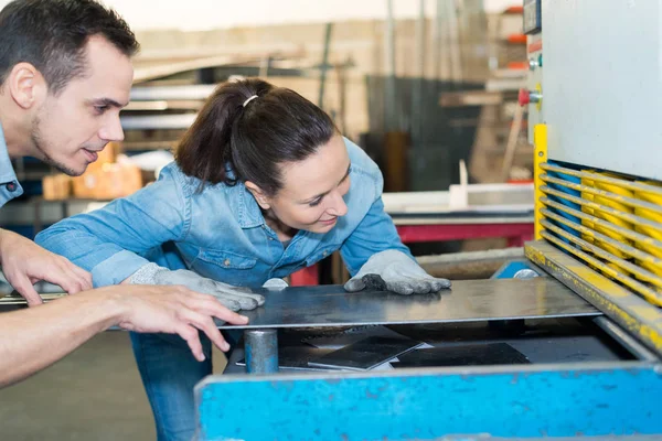 Mannelijke en vrouwelijke werknemers in de fabriek van metalworks — Stockfoto