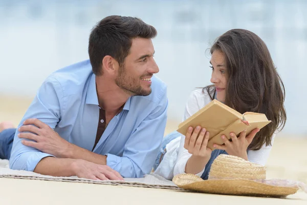 Casal feliz no amor lendo um livro na praia — Fotografia de Stock