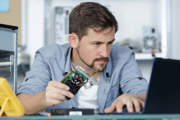 Reparador de computadoras mirando en el ordenador portátil — Foto de Stock