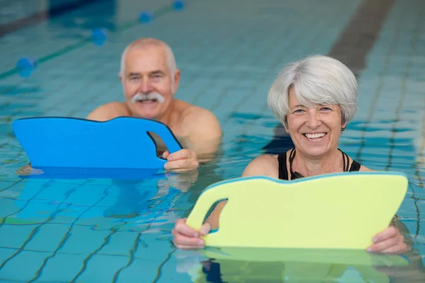 Glückliches Senioren-Paar schwimmt im Pool — Stockfoto