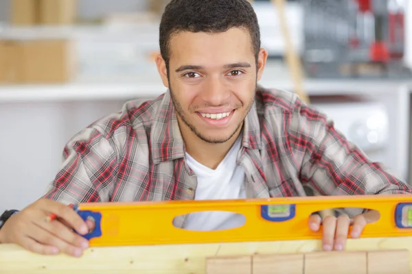 Porträt eines jungen Handwerker mit Wasserwaage — Stockfoto