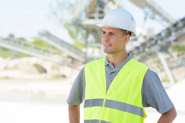 Young male engineer inspecting something outdoors — Stock Photo, Image