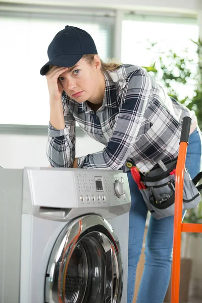 Donna sconvolta che si occupa di una lavatrice pesante — Foto Stock
