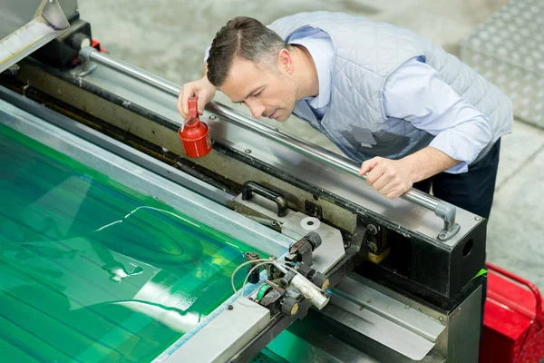 Hombre trabajando en la fábrica de impresión —  Fotos de Stock