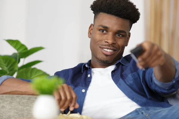 Imagen del joven sosteniendo el control remoto — Foto de Stock