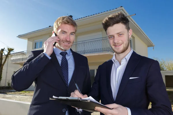 Pleine longueur de jeunes hommes d'affaires avec presse-papiers à l'extérieur — Photo