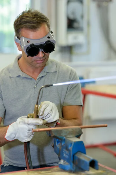 Homem com óculos de proteção soldagem em uma fábrica — Fotografia de Stock