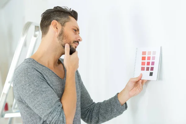 Man overweegt kleurenschema voor muur — Stockfoto
