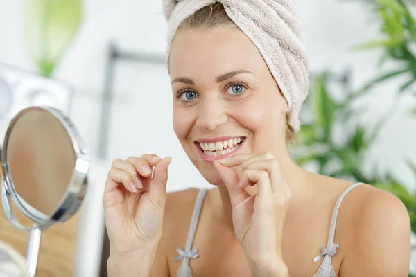 Retrato de mulher bonita limpando dentes com fio dental — Fotografia de Stock