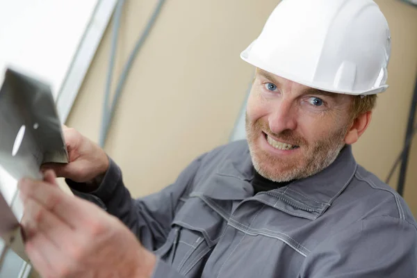 Веселый бородатый строитель смотрит в камеру — стоковое фото