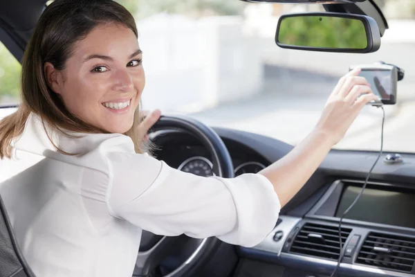 Mulher feliz olhando para gps no carro — Fotografia de Stock
