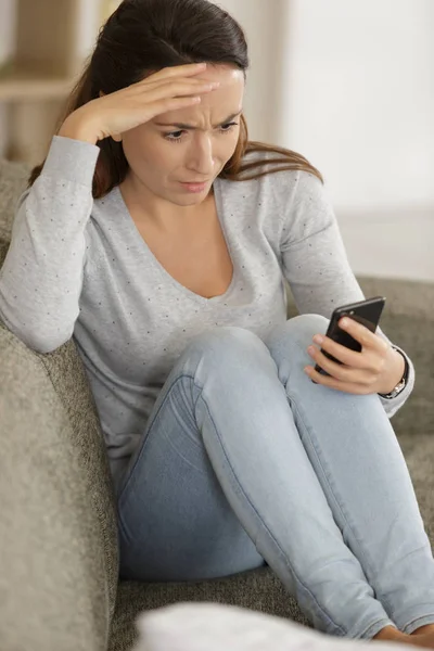 Chockad kvinna tittar på hennes telefon — Stockfoto