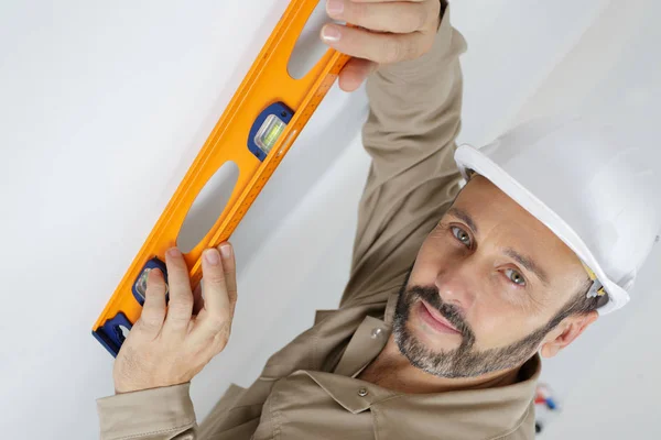 Portrait of middle-aged tradesman using spirit level — Stock Photo, Image