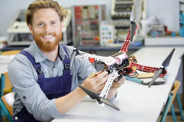 Hombre feliz arreglando un dron — Foto de Stock