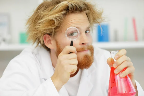 Lab worker with a magnifying glass — Stock Photo, Image