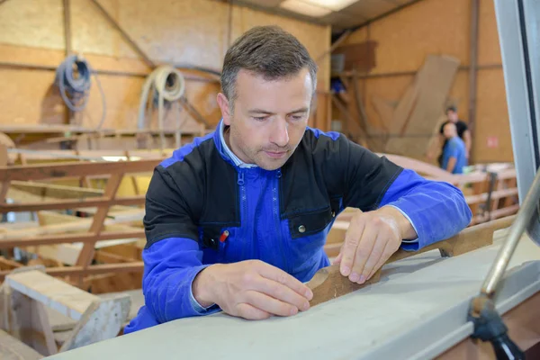 Man schildert een houten object uit de workshop — Stockfoto