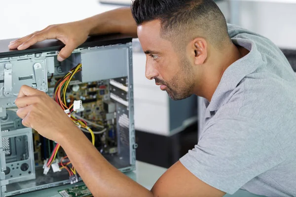 Mannen i glasögon tittar på kameran medan han fastställande pc — Stockfoto