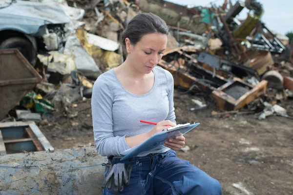 Junkyard trabajador escribir en el portapapeles — Foto de Stock