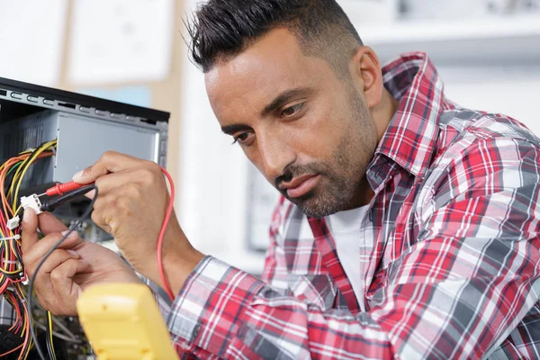 Engenheiro elétrico verificando um pc — Fotografia de Stock