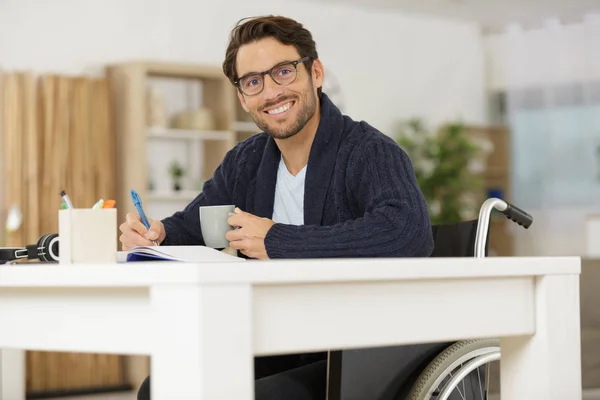 Улыбающийся молодой человек в инвалидном кресле — стоковое фото