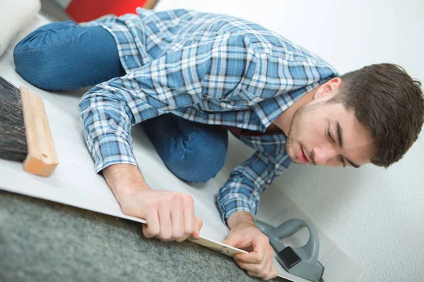 Flooring setter examining the material underneath — Stock Photo, Image