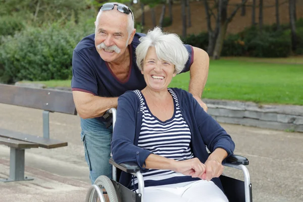 Senior man med en trevlig kvinna i wheelleds — Stockfoto