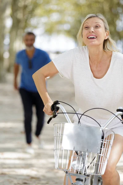 Äldre par cykling på park — Stockfoto