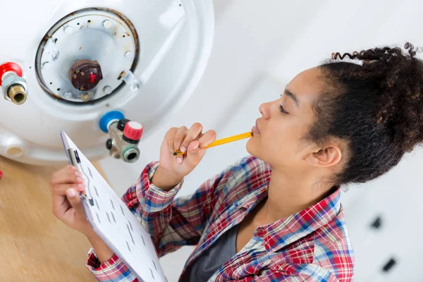 Female plumber working on central heating boiler — Stock Photo, Image