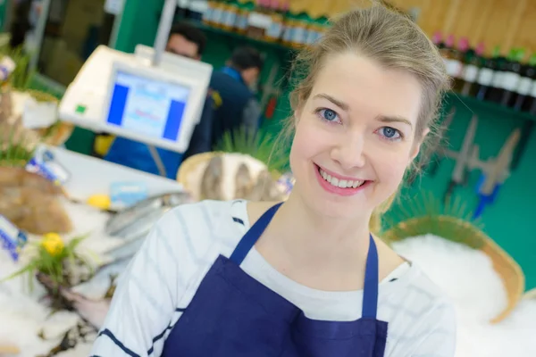Счастливая женщина работает на прилавке в рыбном магазине — стоковое фото