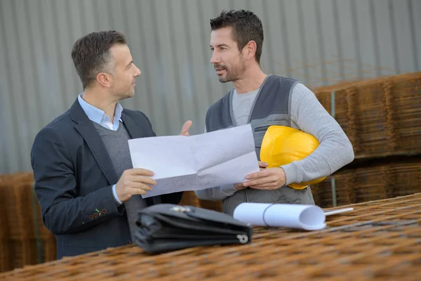 Male workers discussing outside industry — Stock Photo, Image