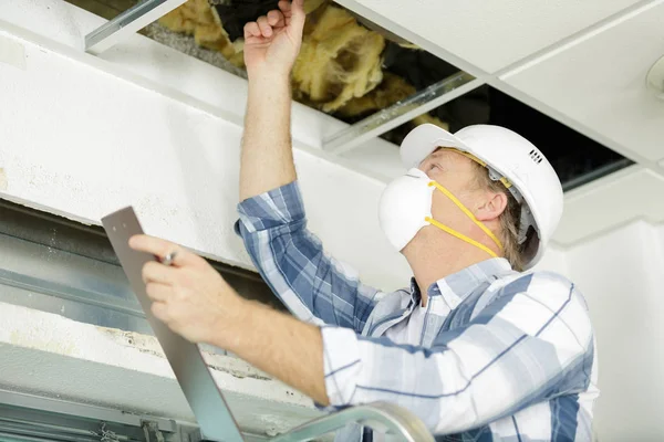 Man werkt aan plafond kabels — Stockfoto