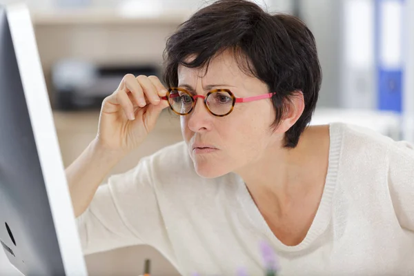 Zakenvrouw in bril staren naar haar computer — Stockfoto