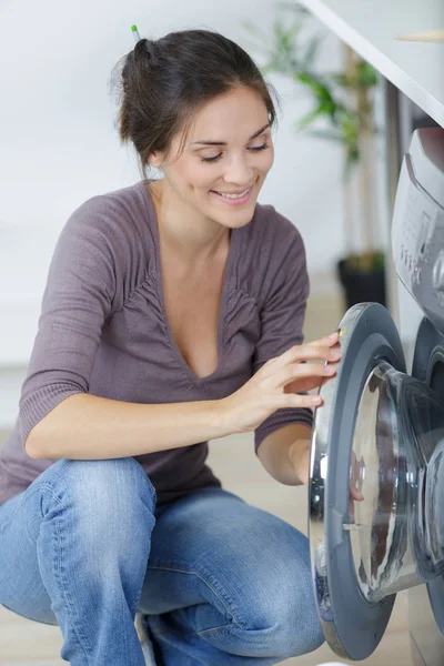 Mujer cargando ropa sucia a mano en lavadora — Foto de Stock