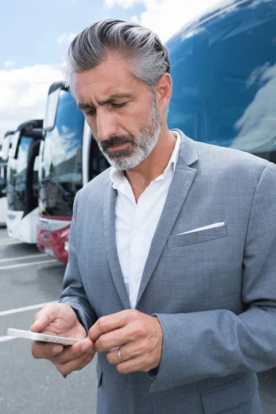 Mannelijke buschauffeur met behulp van zijn telefoon — Stockfoto