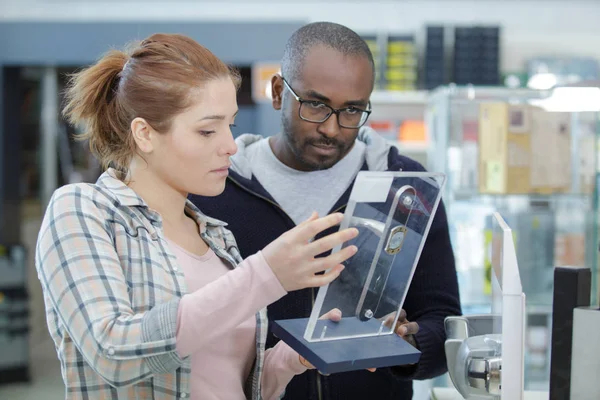 Pareja joven en tienda de electrónica de consumo — Foto de Stock