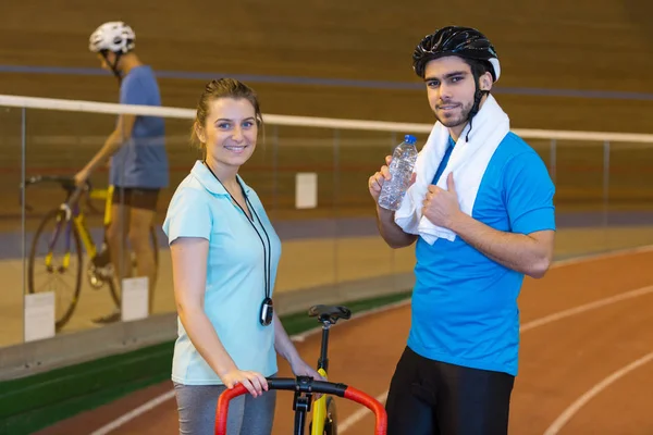 벨로드롬에서 엄지 손가락을 보여주는 코치와 자전거 타기 — 스톡 사진