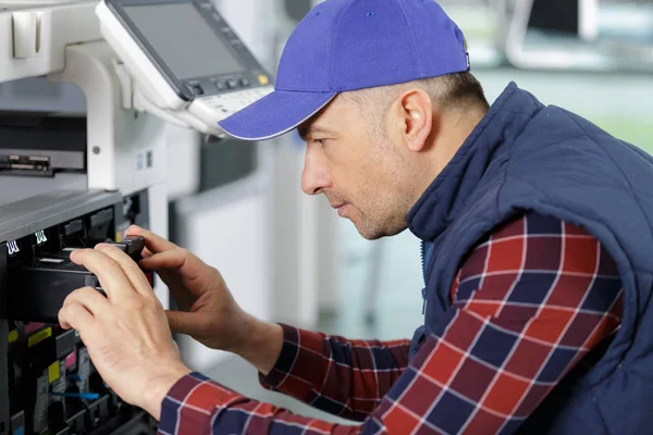 Homem com chave de fenda na impressora de fixação manual — Fotografia de Stock