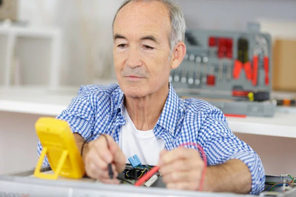 Ανώτερος ενήλικος ηλεκτρολόγος χρησιμοποιώντας ηλεκτρική πένα δοκιμής — Φωτογραφία Αρχείου