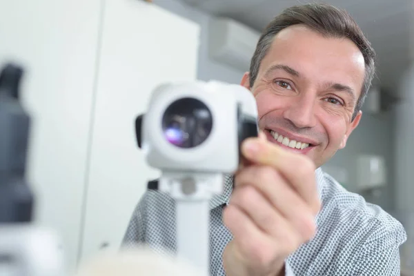 Retrato de óptico feliz usando lámpara de hendidura en la clínica — Foto de Stock