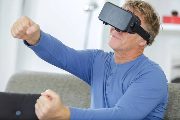 Senior utilisant la réalité virtuelle sur un canapé-lit — Photo