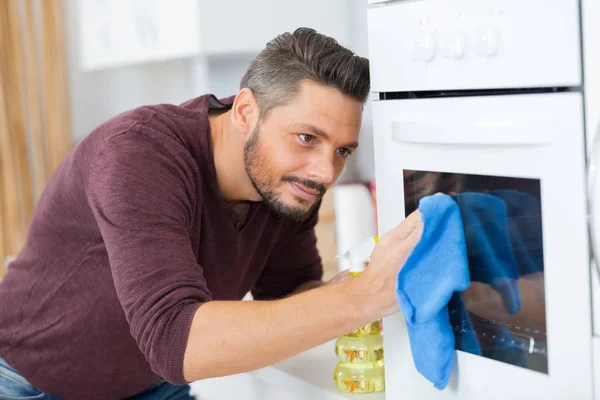 Mann putzt Ofen und Mann — Stockfoto
