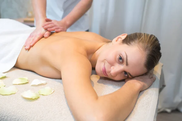 Vacker kvinna leende som hon njuter av en ryggmassage — Stockfoto