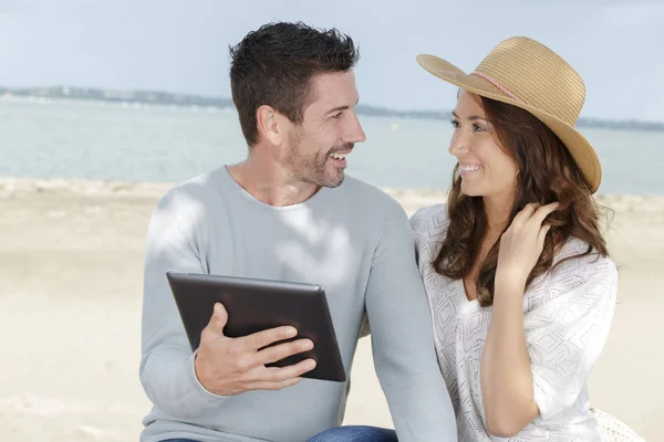 Sahil kasabasında dijital tablet kullanan genç çift — Stok fotoğraf