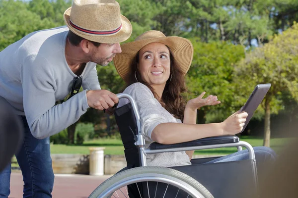 Couple heureux en fauteuil roulant à la recherche d'un itinéraire — Photo