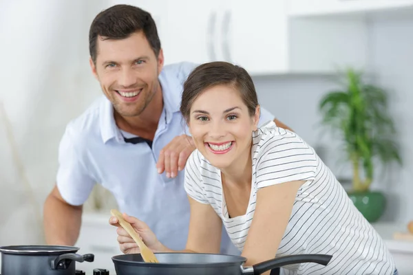 Pareja joven preparando comida juntos — Foto de Stock