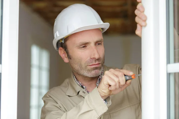 Constructor de ventanas que trabaja en el montaje de la nueva instalación —  Fotos de Stock