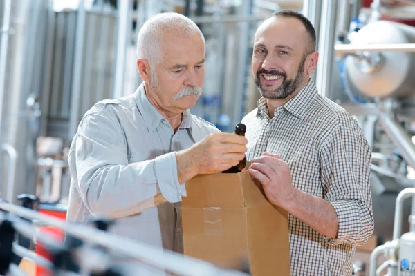 Retrato de dois alegres trabalhadores sorridentes que trabalham na fábrica de cerveja — Fotografia de Stock